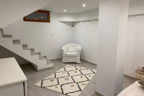 a room with a staircase with a chair and a rug at Villa des Oliviers avec piscine in Chassagny