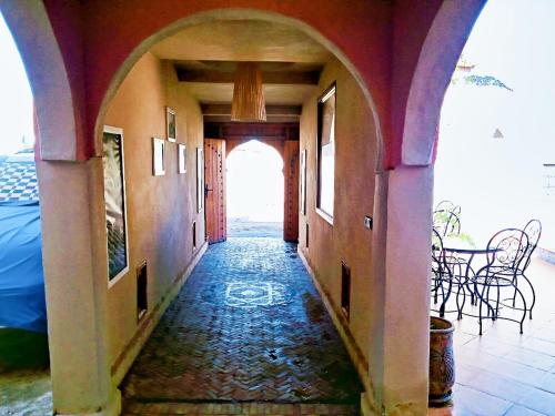 an empty hallway with an archway in a building at Riad Dar Poublanc in Merzouga