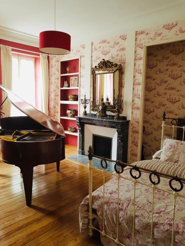 Cette chambre comprend un lit, un miroir et un piano. dans l'établissement Chez Louise, à Albi