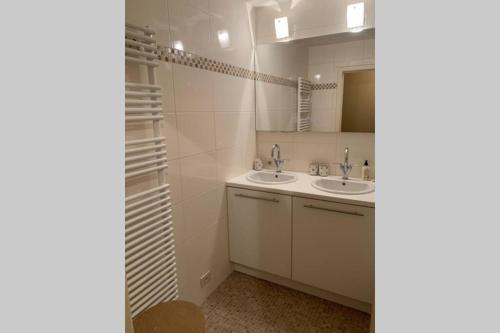 uma casa de banho com 2 lavatórios e um espelho em Two bedroom apartment - 50 meters from beach and KYC em Koksijde