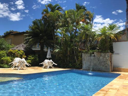 ein Pool mit zwei Pferdestatuen neben einem Haus in der Unterkunft Apartamento estilo Chalé com piscina in Ubatuba