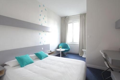 ブレストにあるLittle Lodge Hôtelのベッドルーム(青い枕の大きな白いベッド付)