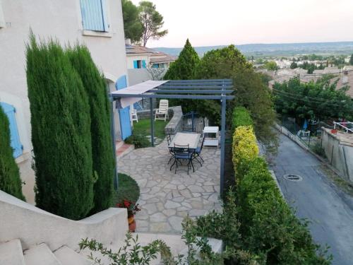 a patio with a table and chairs under a pergola at RdC-villa_2Pieces 35m2_domine la plaine entre NIMES_CEVENNES_MER in Calvisson
