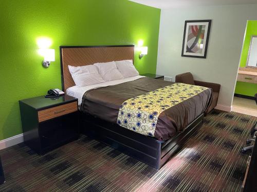 a bedroom with a bed and a green wall at Bowers Hill Inn Chesapeake in Chesapeake