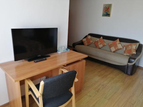 a living room with a television and a couch at Kolpinghaus in Caransebeş