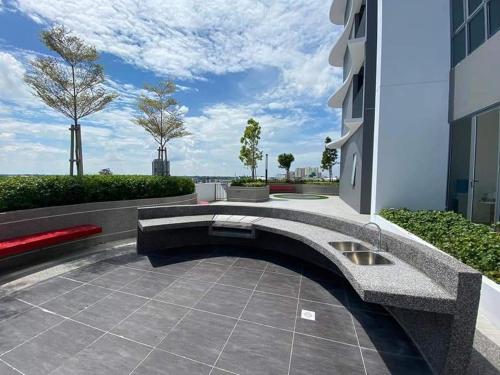 eine Terrasse mit einer Bank und einem Gebäude in der Unterkunft AuranadTroikaKB Apartment Wifi-Netflix-Coway in Kota Bharu