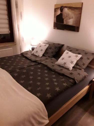 łóżko z czarno-białą pościelą i poduszkami w obiekcie Wunderschöne Ferienwohnung ´Mal seh´n`direkt am Nordseedeich w mieście Friedrichskoog-Spitz