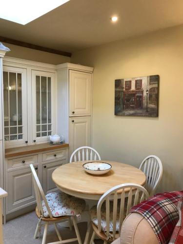 a kitchen with a wooden table and chairs at courtyard cottage in Kendal