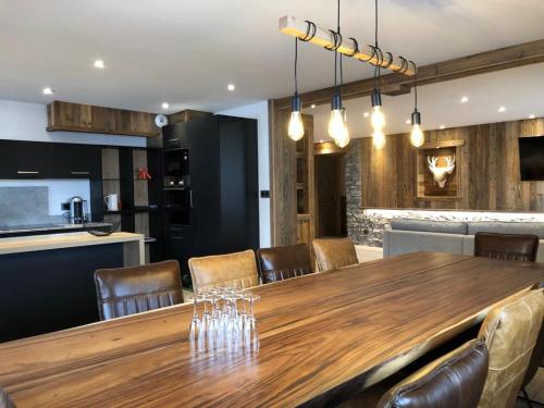 a dining room and kitchen with a wooden table and chairs at Résidence Julianna , trajets remontées mécaniques , livraison viennoiseries, piscine couverte in Morzine