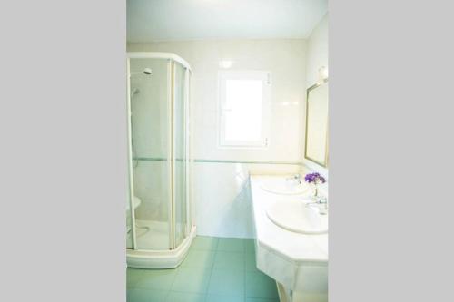 a white bathroom with a sink and a shower at Casa para 10 personas en campo de golf Añoreta in Torre de Benagalbón