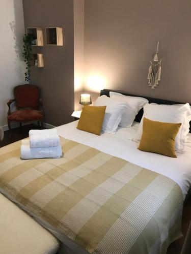 a bedroom with a large bed and a chair at Maison 4 chambres jardin et parking in Déols