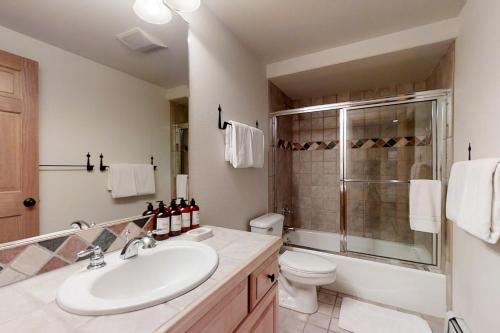 Un baño con lavabo, inodoro y ducha. en Evergreens 03, en Steamboat Springs