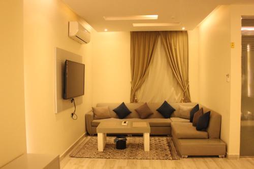 Open Hotel في الرياض: غرفة معيشة مع أريكة وتلفزيون