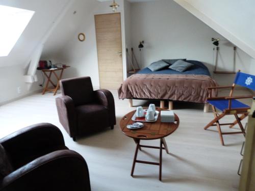 Le Clos de l'Abré في Gatteville-le-Phare: غرفة نوم بسرير وطاولة وكراسي