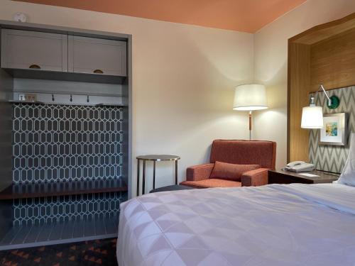 a hotel room with a bed and a chair and a phone at Holiday Inn Bangor by IHG in Bangor