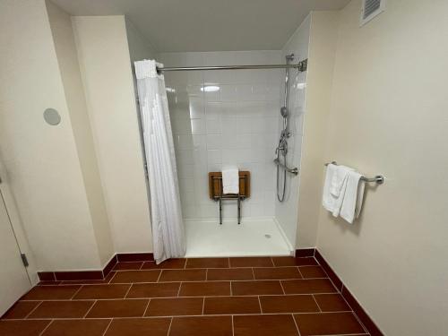 a bathroom with a shower and a tiled floor at Holiday Inn Bangor by IHG in Bangor