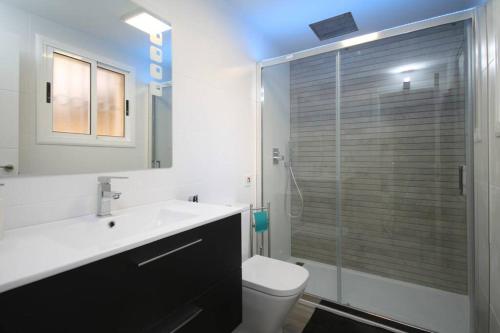 uma casa de banho com um WC e uma cabina de duche em vidro. em Apartamento frente al mar en Cambrils em Cambrils