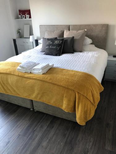 a bedroom with a large bed with a yellow blanket at reflections luxury modern accommodation in Saint Monance