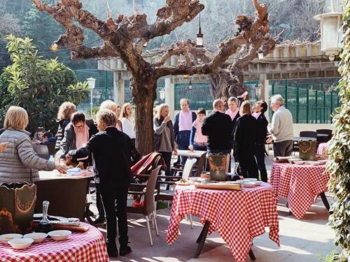 a group of people standing around tables in a courtyard at Hotel Robert in La Pobla de Claramunt