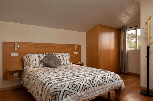 um quarto com uma cama grande e uma cabeceira em madeira em Martinho Apartment View em Arco da Calheta