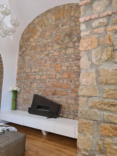 a stone wall with a tv in a living room at Incantevole con Jacuzzi in Rome