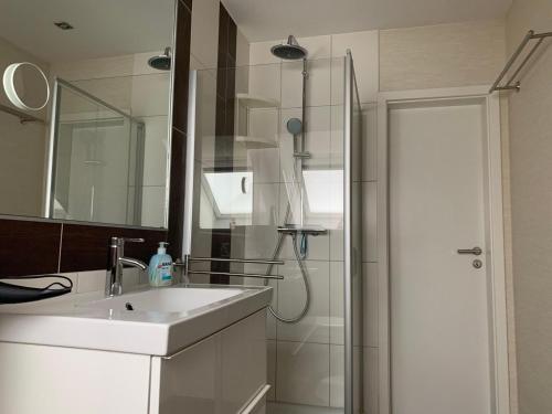 a white bathroom with a sink and a shower at Haus-Encore-Wohnung-4 in Büsum