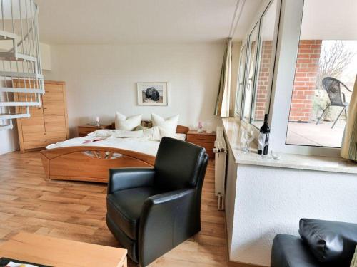 ein Schlafzimmer mit einem Bett und einem Stuhl darin in der Unterkunft Gemeinsamzeit-auf-2-Etagen-im-App-27-Strandhafer in Timmendorfer Strand