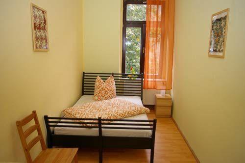 Schlafzimmer mit einem Bett und einem Fenster in der Unterkunft  3R Fewo bis 8 Personen zentral T8 in Dresden