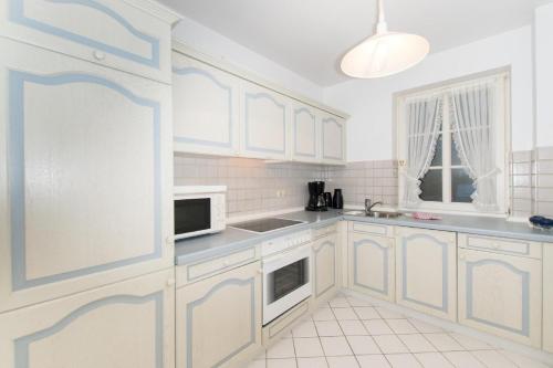 a kitchen with white cabinets and white appliances at Westhof-4 in List