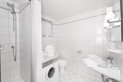 a white bathroom with a toilet and a sink at Westhof-4 in List