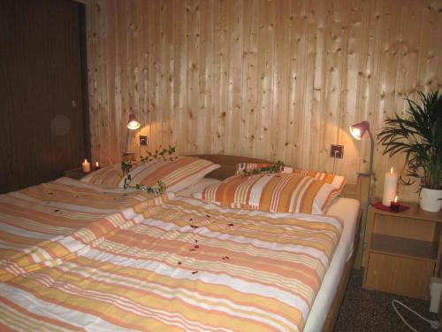 two beds in a room with wood paneled walls at Bungalow in Hermsdorf