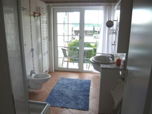 ein Bad mit einem Waschbecken und einem WC sowie einen Balkon in der Unterkunft Ferienwohnungen Roder - Ferienwohnung III in Freiburg im Breisgau