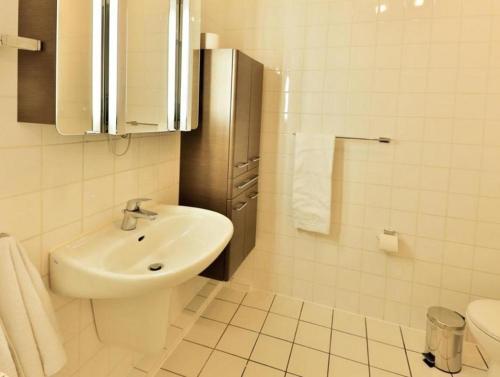 ein weißes Bad mit einem Waschbecken und einem WC in der Unterkunft großes Appartement 28 - Sandkiste in Timmendorfer Strand