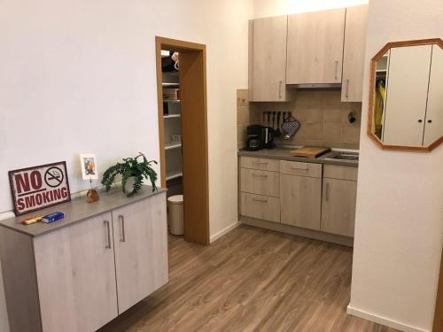 uma cozinha com armários brancos e piso em madeira em Sport-Alpin-Wohnung-5 em Oberstdorf