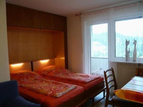 een slaapkamer met 2 bedden en een raam bij Falkenhorst-Wohnung-40 in Oberstdorf