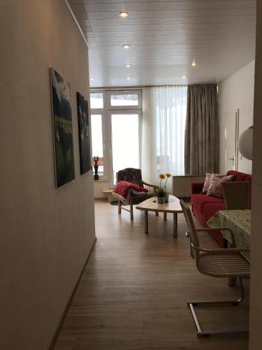 een woonkamer met een rode bank en een tafel bij Sport-Alpin-Wohnung-4 in Oberstdorf