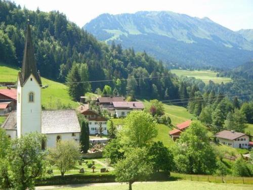 ein kleines Dorf mit einer Kirche in den Bergen in der Unterkunft Sport Alpin Wohnung 4 in Oberstdorf