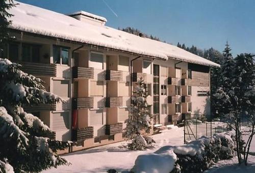 ein großes Gebäude mit Schnee an der Seite in der Unterkunft Falkenberg Wohnung 211 in Oberstdorf