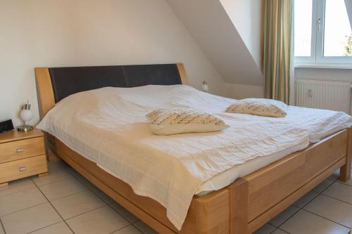 ein Bett mit zwei Kissen darauf in einem Schlafzimmer in der Unterkunft Appartement Seeluft 17 - Durchatmen und Entspannen in Timmendorfer Strand