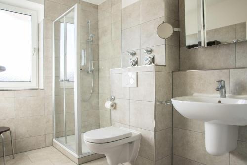 ein Bad mit einem WC, einem Waschbecken und einer Dusche in der Unterkunft Appartement Seeluft 17 - Durchatmen und Entspannen in Timmendorfer Strand