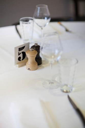 a table with wine glasses and a number on it at Hôtel et Spa La Villa K - Basel Airport in Saint-Louis