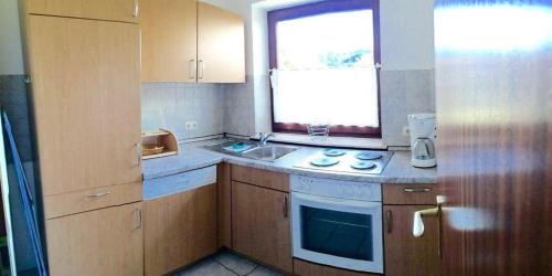 eine kleine Küche mit einem Waschbecken und einem Fenster in der Unterkunft 2-Zimmer-Appartement im Ostseehaus Petersen in Grömitz