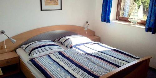 ein Bett mit zwei Kissen darauf in einem Schlafzimmer in der Unterkunft 2-Zimmer-Appartement im Ostseehaus Petersen in Grömitz