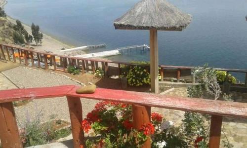 a wooden railing with a view of the ocean at Hostal Qhana Pacha in Isla de la Luna