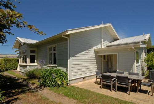 a house with a table and chairs in front of it at One Panama in Martinborough 