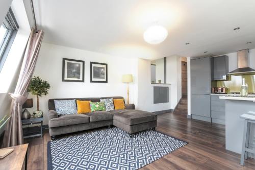 a living room with a couch and a kitchen at The Penthouses, 8 Albion Mews in Chester