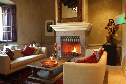 a living room with a fireplace with couches and a table at San Rafael Hotel in Antigua Guatemala