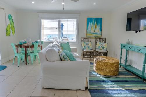 ein Wohnzimmer mit einem weißen Sofa und einem Tisch in der Unterkunft Anna Maria Island Inn in Bradenton Beach