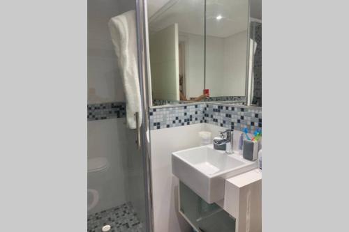 a bathroom with a sink and a shower and a mirror at Apartamento en Arenas del Mar, Punta del Este in Punta del Este