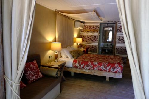 a bedroom with a bed and a couch and a mirror at The Laurels of Chinchilla in Chinchilla
